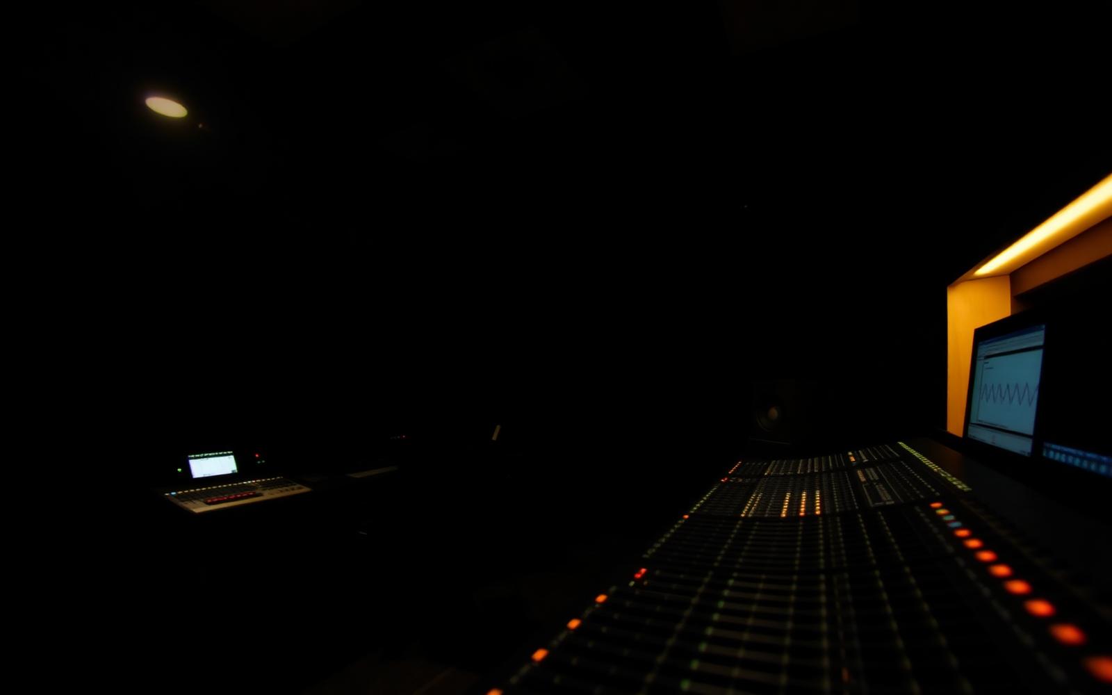 Dark studio control room lit with gold accent light